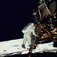 Buzz Aldrin climbs down the Eagle's ladder to the moon surface.”><BR CLEAR=
